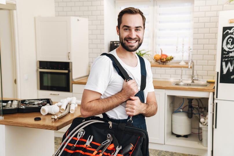 e-signature-software for home service firms  - image-of-plumber-man-smiling-and-holding-bag